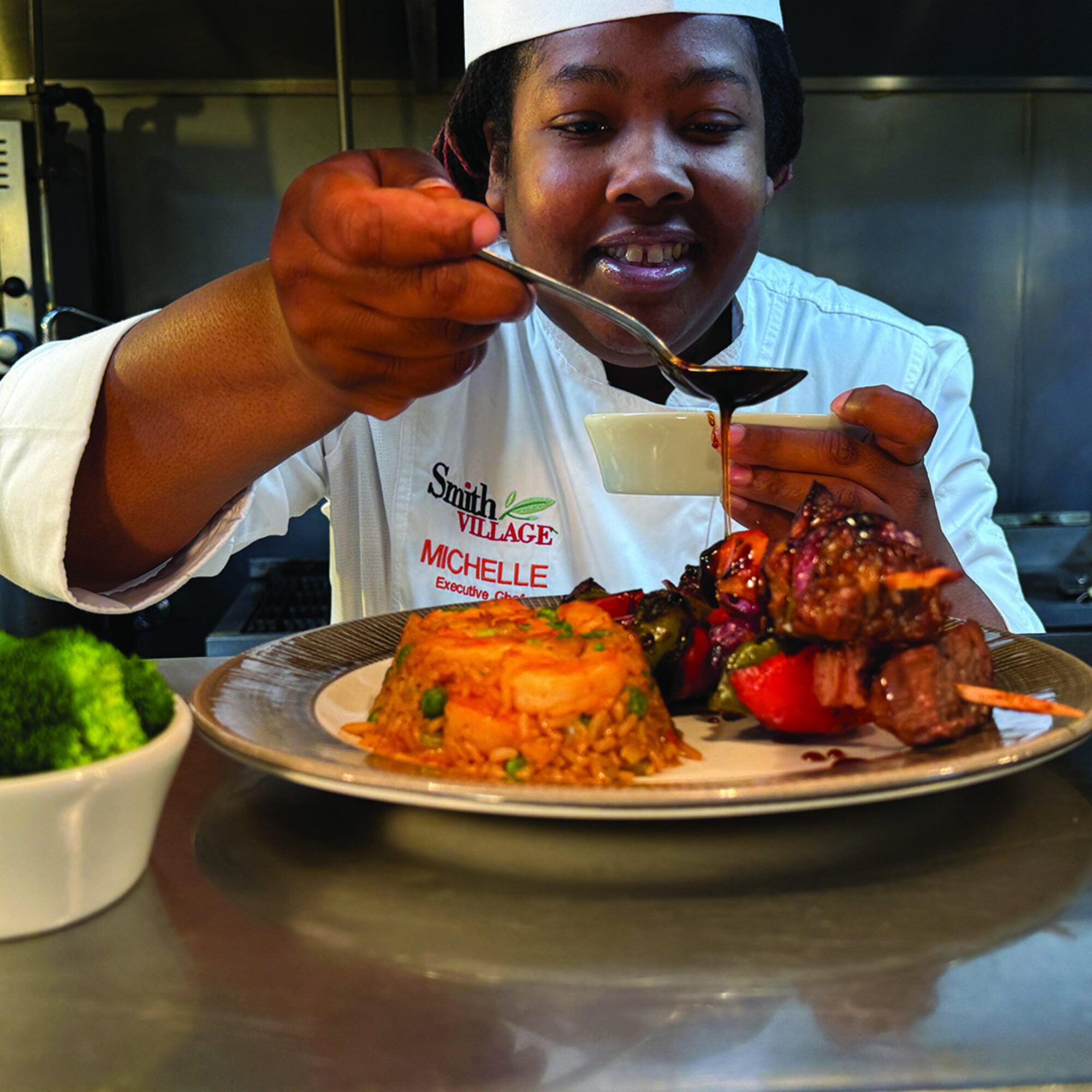 Chef adding the finishing touches to dinner at Smith Village